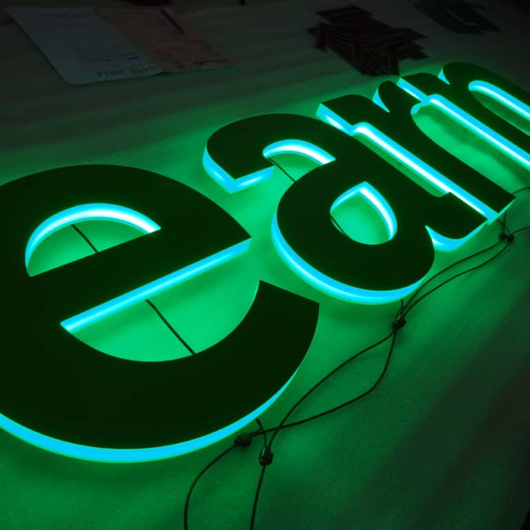Backlit writing using green faux neon lighting. Bespoke neon signs made with eco-friendly LEDs by NeonPlus