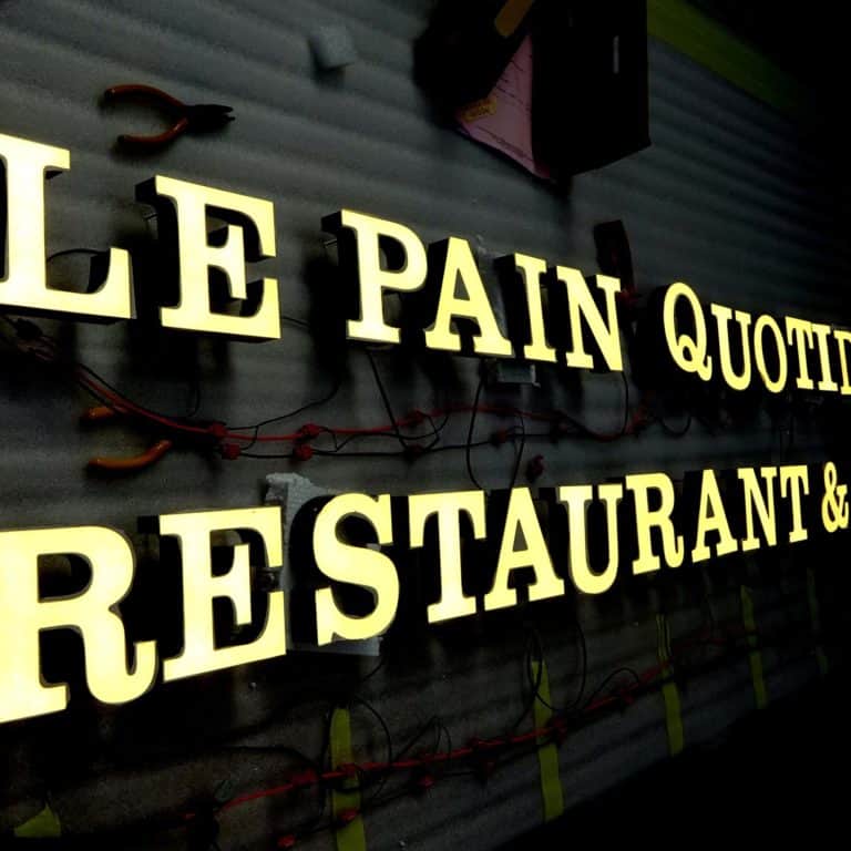 Le Pain Quotidien logo and text in serif font. Illuminated with warm white LEDs