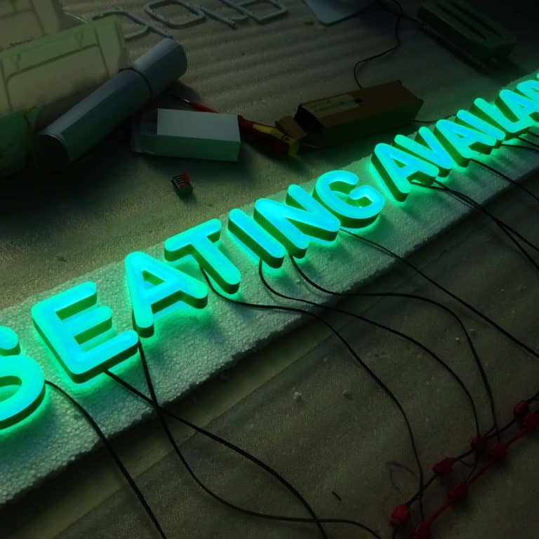 Green block capital neon sign alternative reading 'Seating Available'. Eco-friendly alternative to neon signs from NeonPlus