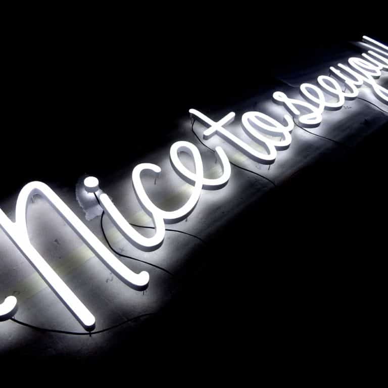 Cursive handwriting sign, in white faux neon for shop signage and merchandising.