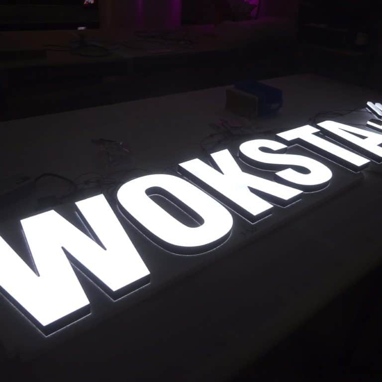 White neon alternative Woksta sign, with block faux neon letters
