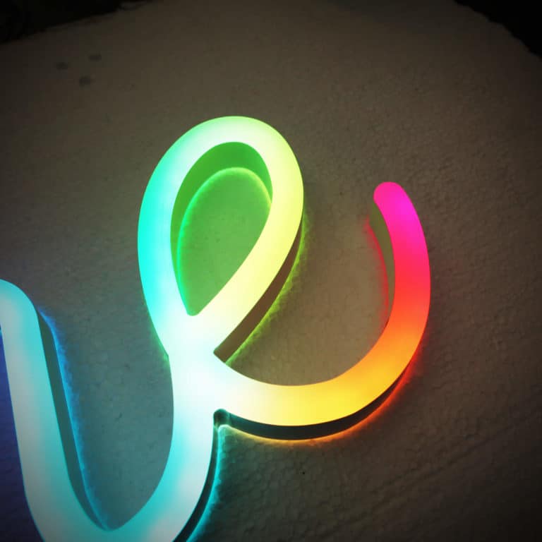 Close up on letter E, rainbow coloured Neon Plus digital