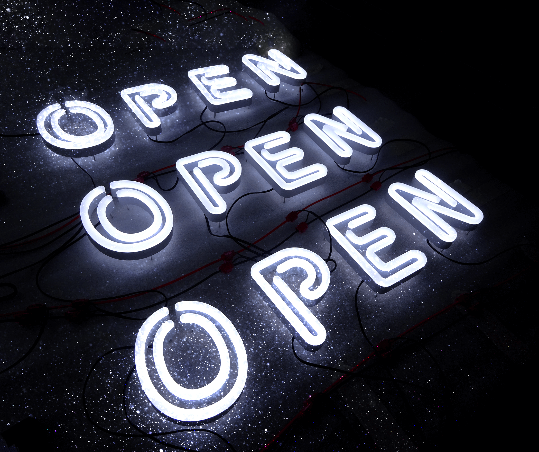 three faux neon open signs on table